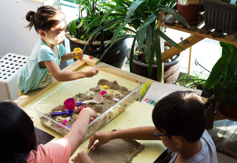 Children playing kinetic sands at home during sunrise due to the lockdown of the Coronavirus or Covid 19 outbreak. Selective focus.